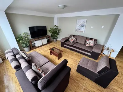 a living room with couches and a flat screen tv at Santa Ana Home Cusco in Cusco