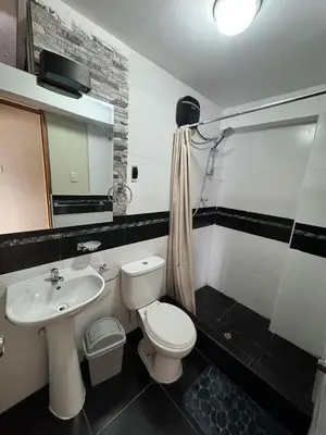 a bathroom with a white toilet and a sink at Santa Ana Home Cusco in Cusco