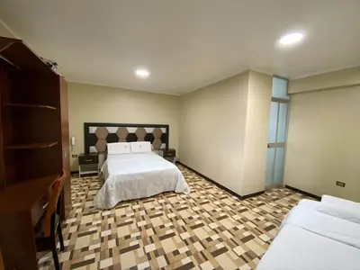 a bedroom with a bed and two twin beds at Hotel Leal in Ayacucho