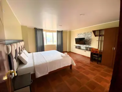 a hotel room with a bed and a television at Hotel Leal in Ayacucho