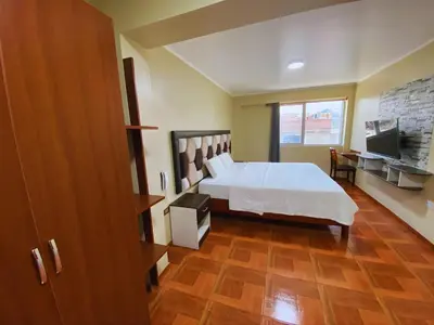 a hotel room with a bed and a television at Hotel Leal in Ayacucho