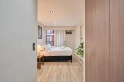 a bedroom with a bed and a desk and a bed sidx sidx sidx at Geko | Contemporary 2BR w/Balcony near Costa Verde in Lima