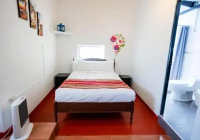 a small bedroom with a bed and a tv at San Blas Plaza Hotel in Cusco