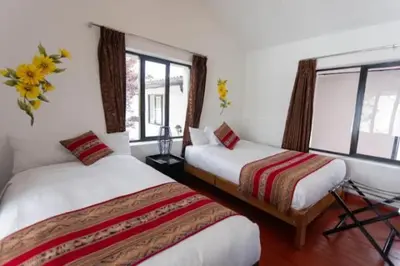 a hotel room with two beds and a window at San Blas Plaza Hotel in Cusco