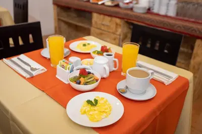 a table topped with plates of food and cups of coffee at San Blas Plaza Hotel in Cusco