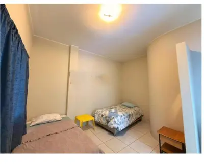 a small bedroom with two beds and a table at CHANCAY- 1er PISO DEPARTAMENTO in Chancay