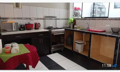 a kitchen with a stove and a table in it at CHANCAY- 1er PISO DEPARTAMENTO in Chancay