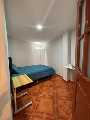 a bedroom with a blue bed and a table in it at 3 bedroom apartment Ayacucho - Perú in Ayacucho