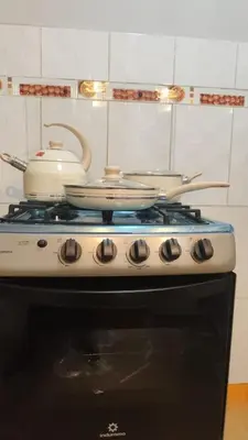 two pots and pans sitting on top of a stove at 3 bedroom apartment Ayacucho - Perú in Ayacucho