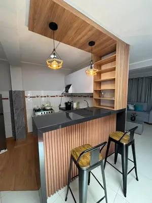 a kitchen with a counter and two chairs and a counter top at 3 bedroom apartment Ayacucho - Perú in Ayacucho
