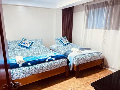 a bedroom with two twin beds and a window at Casa de Paz in Cusco