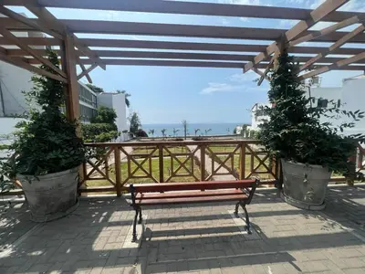 a bench sitting under a pavilion with a view of the ocean at Departamento cerca al mar con terraza panoramica in Lima