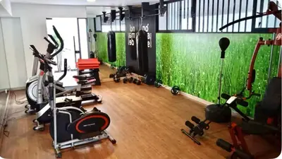 a gym with exercise equipment and a green wall at Departamento cerca al mar con terraza panoramica in Lima