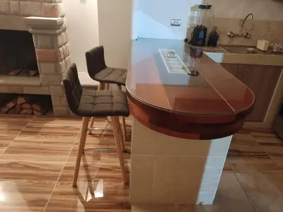 a kitchen with a counter and two bar stools at Wasi Wasi in Urubamba