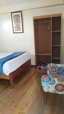 a bedroom with a bed and a couch and a chair at San Blas B&B in Cusco