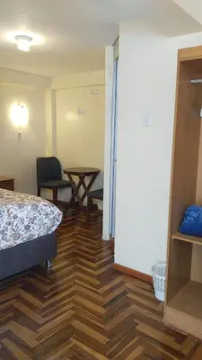 a room with a bed and a wooden floor at San Blas B&B in Cusco