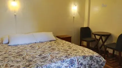 a hotel room with a bed and two chairs at San Blas B&B in Cusco