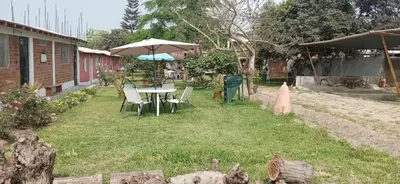 a table and chairs and an umbrella in a yard at La Viña de OsCar in Nuevo Imperial