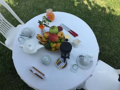 a white table with a bowl of fruit on it at La Viña de OsCar in Nuevo Imperial