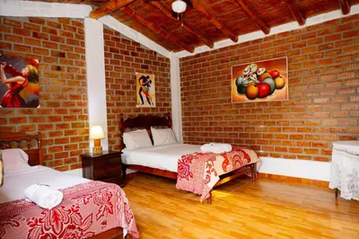 a room with two beds and a brick wall at La Viña de OsCar in Nuevo Imperial
