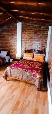 a bedroom with a large bed in a brick wall at La Viña de OsCar in Nuevo Imperial