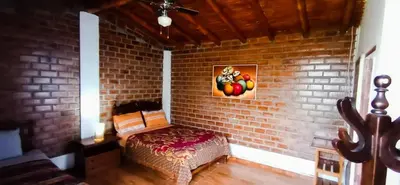 a brick wall with a bench in a room at La Viña de OsCar in Nuevo Imperial