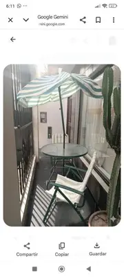 a table and a chair with an umbrella and a cactus at Hospedaje Dajoka's in Lima