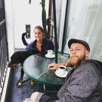 a man is sitting at a table with a dog at Hospedaje Dajoka's in Lima