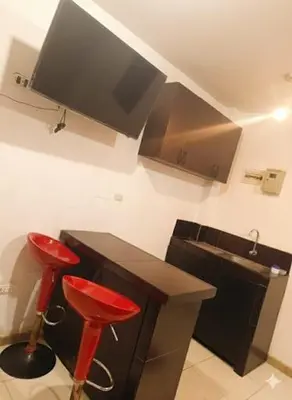 a kitchen with two red stools next to a counter at Hospedaje Dajoka's in Lima
