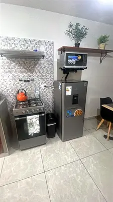 a miniature kitchen with a stove and a refrigerator at Equipped Loft with Sofa Bed and Balcony in Lima