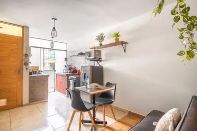 a kitchen and living room with a table and chairs at Equipped Loft with Sofa Bed and Balcony in Lima