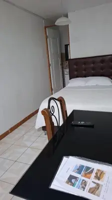 a hotel room with a bed and a table with a magazine at Lindo Atardecer in Ica
