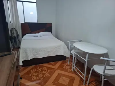 a small bedroom with a bed and a chair at Lindo Atardecer in Ica