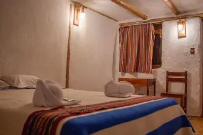 a bedroom with a bed with hats on it at Unu Samay Lodge in Urubamba