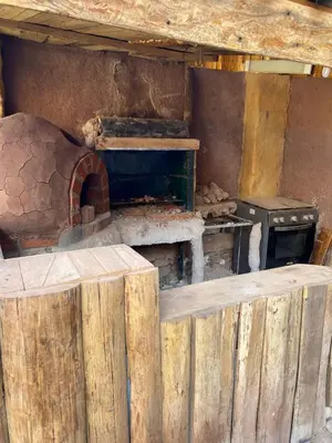 a kitchen with an oven and a wooden fence at Unu Samay Lodge in Urubamba