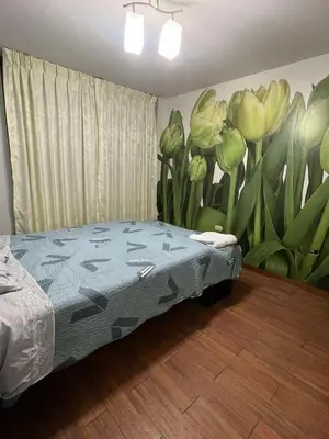 a bedroom with a bed with a mural of flowers at Las palmeras in Lima