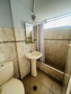 a bathroom with a toilet and a sink at Las palmeras in Lima