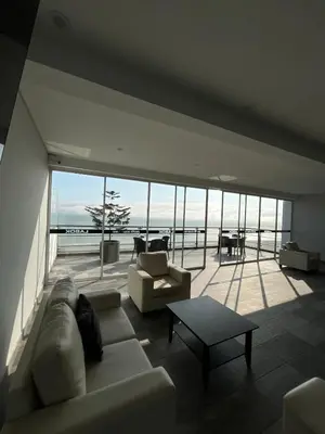 a living room with a couch and a table at Oceanfront apartment, Pool, Gym, Sauna, Arcade in Lima