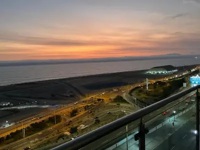 a view of the ocean and a city at night at Oceanfront apartment, Pool, Gym, Sauna, Arcade in Lima