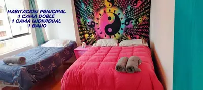 a bedroom with a pink bed with a colorful wall at inti angelus house rooms in Cusco