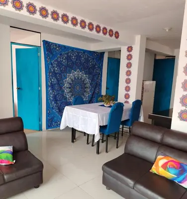 a dining room with a table and chairs and a blue rug at inti angelus house rooms in Cusco
