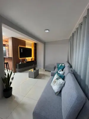 a living room with a blue couch and a television at Central and brand new apartment in Huamanga in Ayacucho