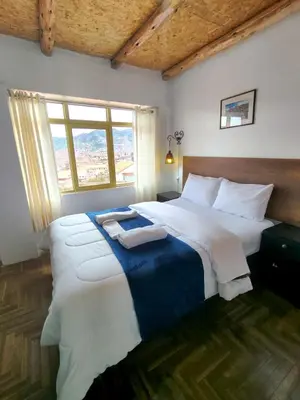 a bedroom with two large beds and a window at Imperial City Apartment in Cusco