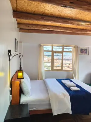 a bedroom with a large bed with a window at Imperial City Apartment in Cusco