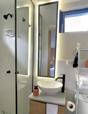 a bathroom with a white sink and a mirror at Tiny Mountain River in Urubamba