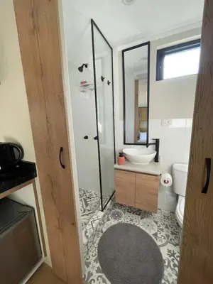 a bathroom with a shower and a toilet and a sink at Tiny Mountain River in Urubamba