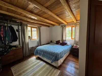 a bedroom with a bed and a wooden ceiling at Casa Nuestra in Urubamba