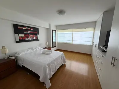 a bedroom with a bed and a television in it at Duplex en miraflores av larco 1010 in Lima