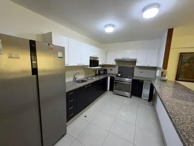 a kitchen with black and white cabinets and appliances at Duplex en miraflores av larco 1010 in Lima