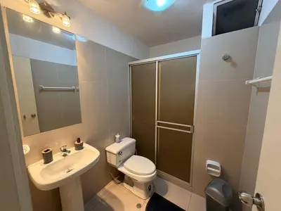 a bathroom with a toilet and a sink and a shower at Duplex en miraflores av larco 1010 in Lima
